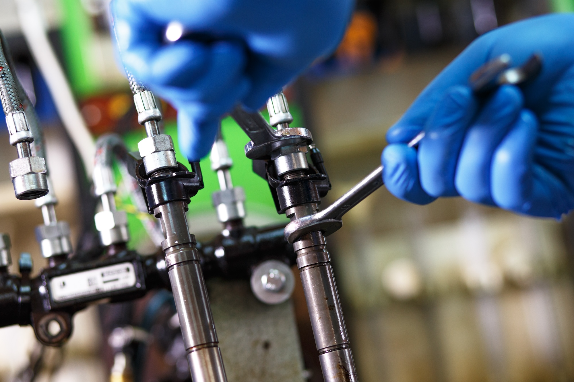 Professional mechanic testing diesel injector in his workshop